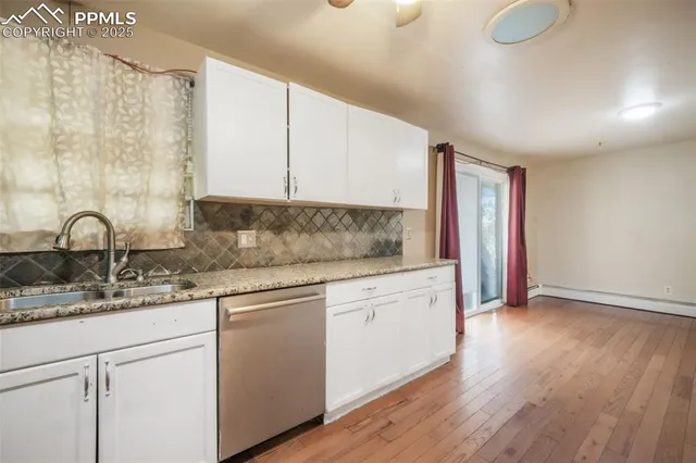 a kitchen with granite countertop white cabinets and sink