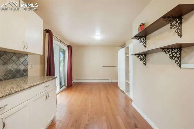 a view of hallway with granite countertop a refrigerator and a sink