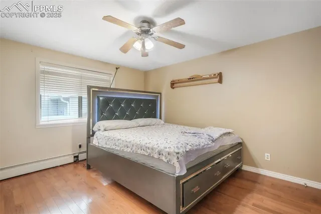 a bed sitting in a bedroom next to a window and a chandelier