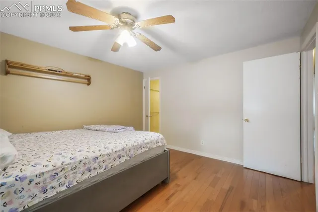a bedroom with a bed and a chandelier fan