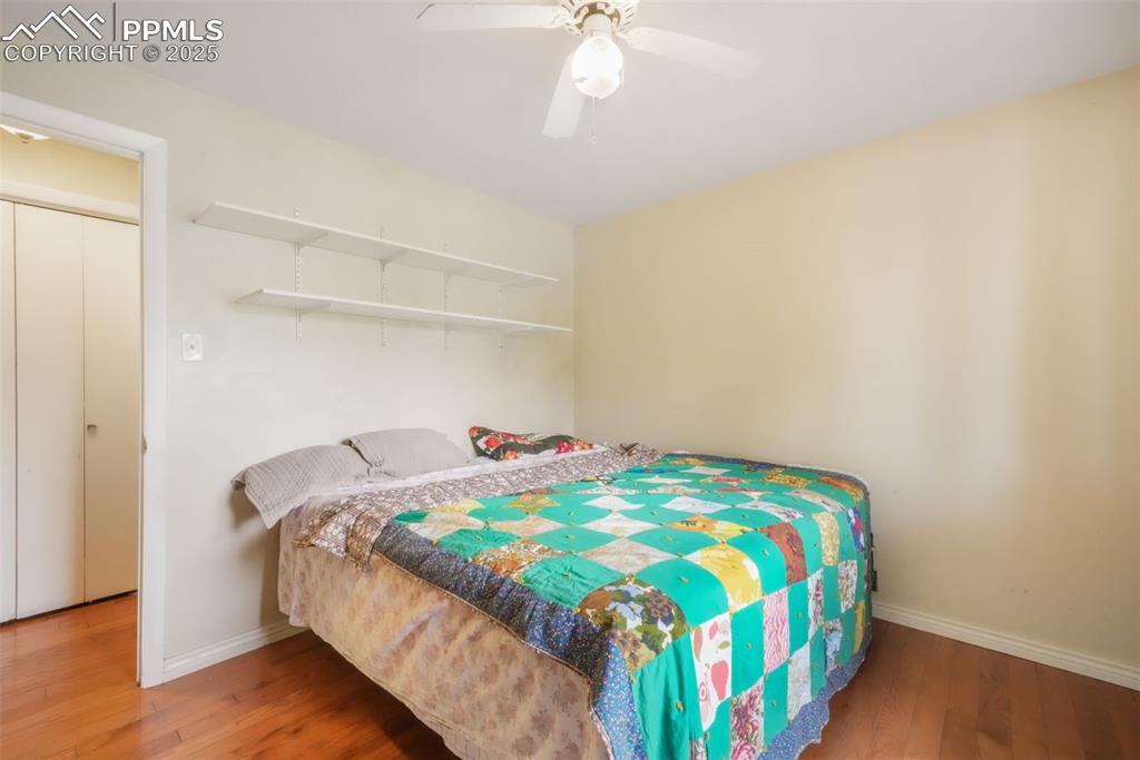 6802 Galley Road Colorado Springs, CO 80915 - Photo 21 of 50 a bedroom with a bed and a chandelier