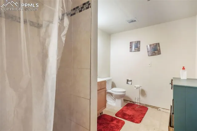 a bathroom with a toilet sink vanity and mirror