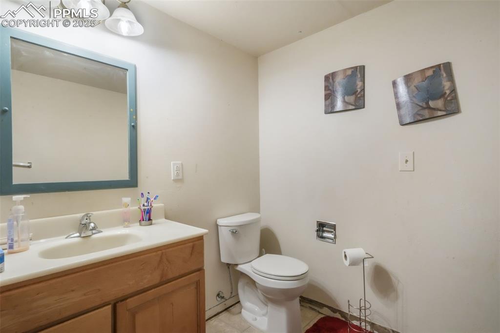 6802 Galley Road Colorado Springs, CO 80915 - Photo 35 of 50 a bathroom with a toilet sink vanity and mirror