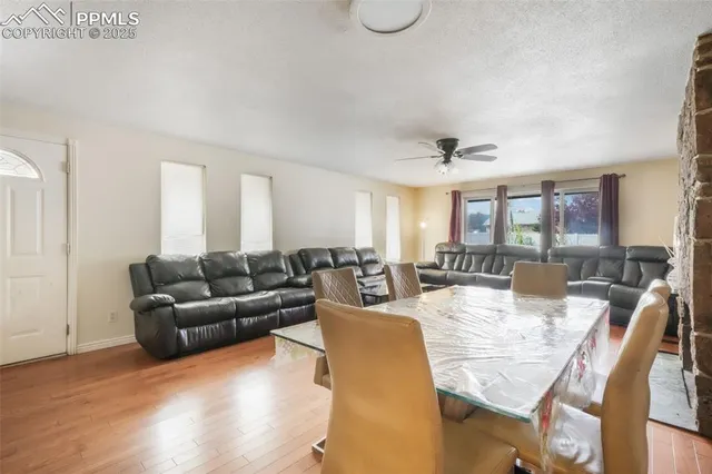 a living room with furniture kitchen view and a large window