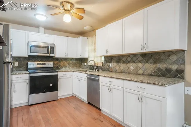 a kitchen with stainless steel appliances granite countertop a stove a sink and a microwave