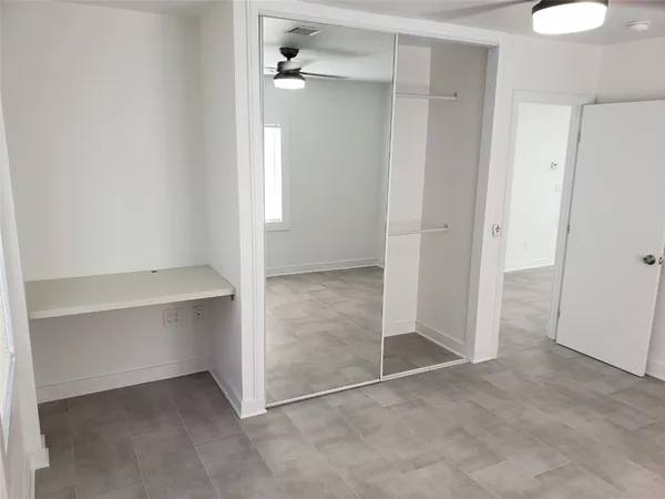 an empty room with windows and closet