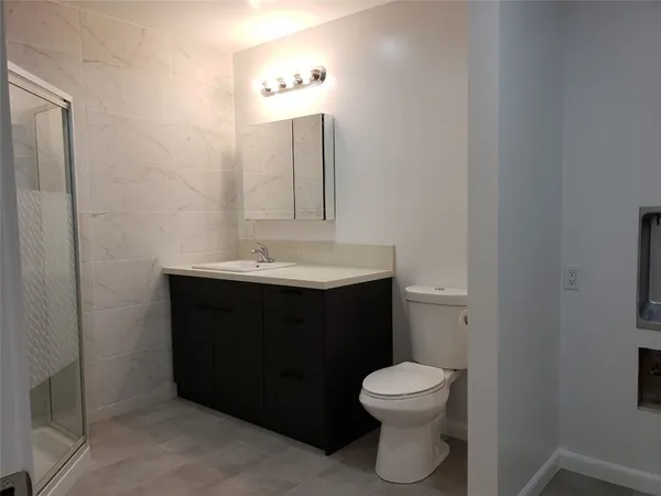 a bathroom with a sink a toilet and a mirror