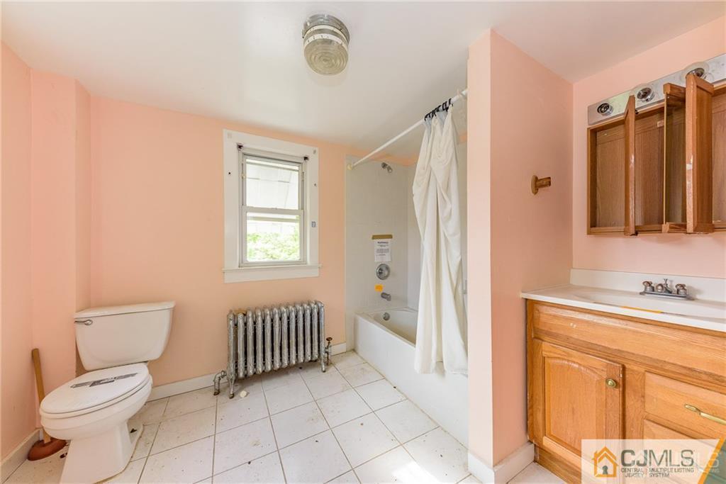 86 Main Street Matawan, NJ 07747 - Photo 13 of 25 a bathroom with a toilet a sink and a mirror