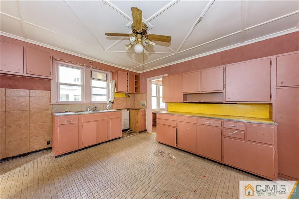 86 Main Street Matawan, NJ 07747 - Photo 7 of 25 a large kitchen with a window wooden floor and stainless steel appliances