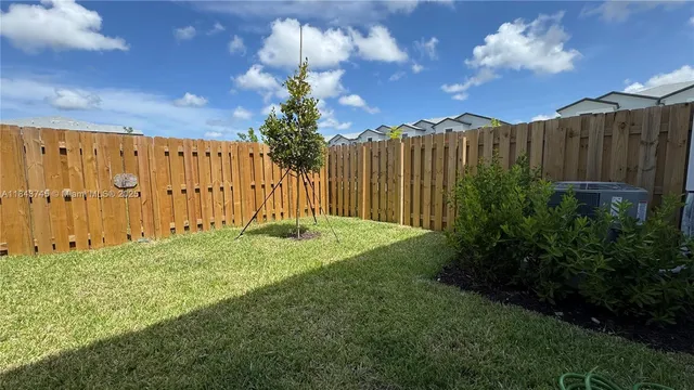 a view of a backyard with potted plants and wooden fence