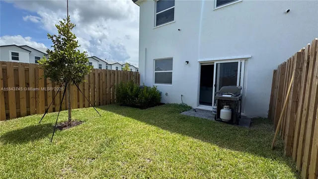 a view of a backyard with potted plants and a large tree