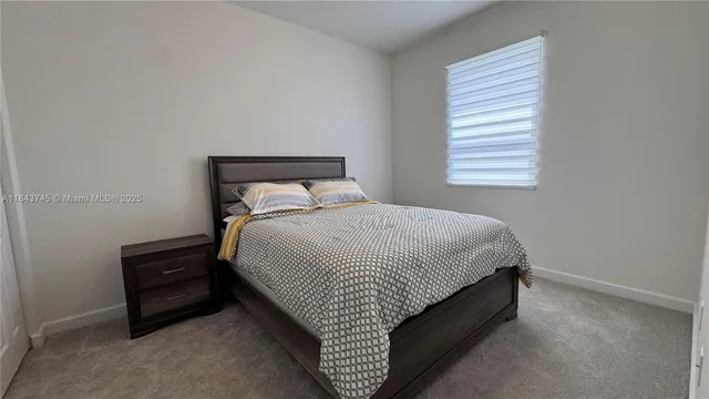 a bed sitting in a bedroom next to a window