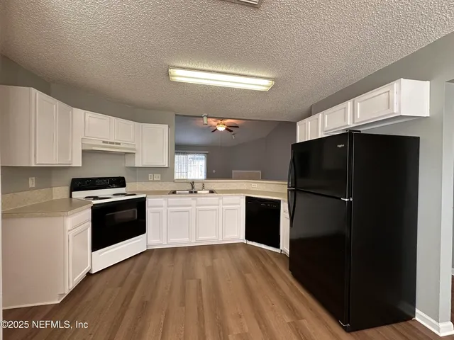 a kitchen with a refrigerator and a stove top oven