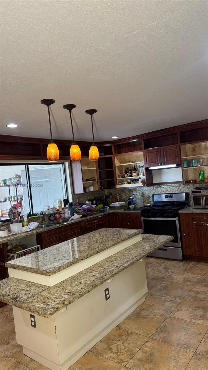 17540 Southwest 254th Street Homestead, FL 33031 - Photo 44 of 85 a kitchen with stainless steel appliances granite countertop a stove and a sink