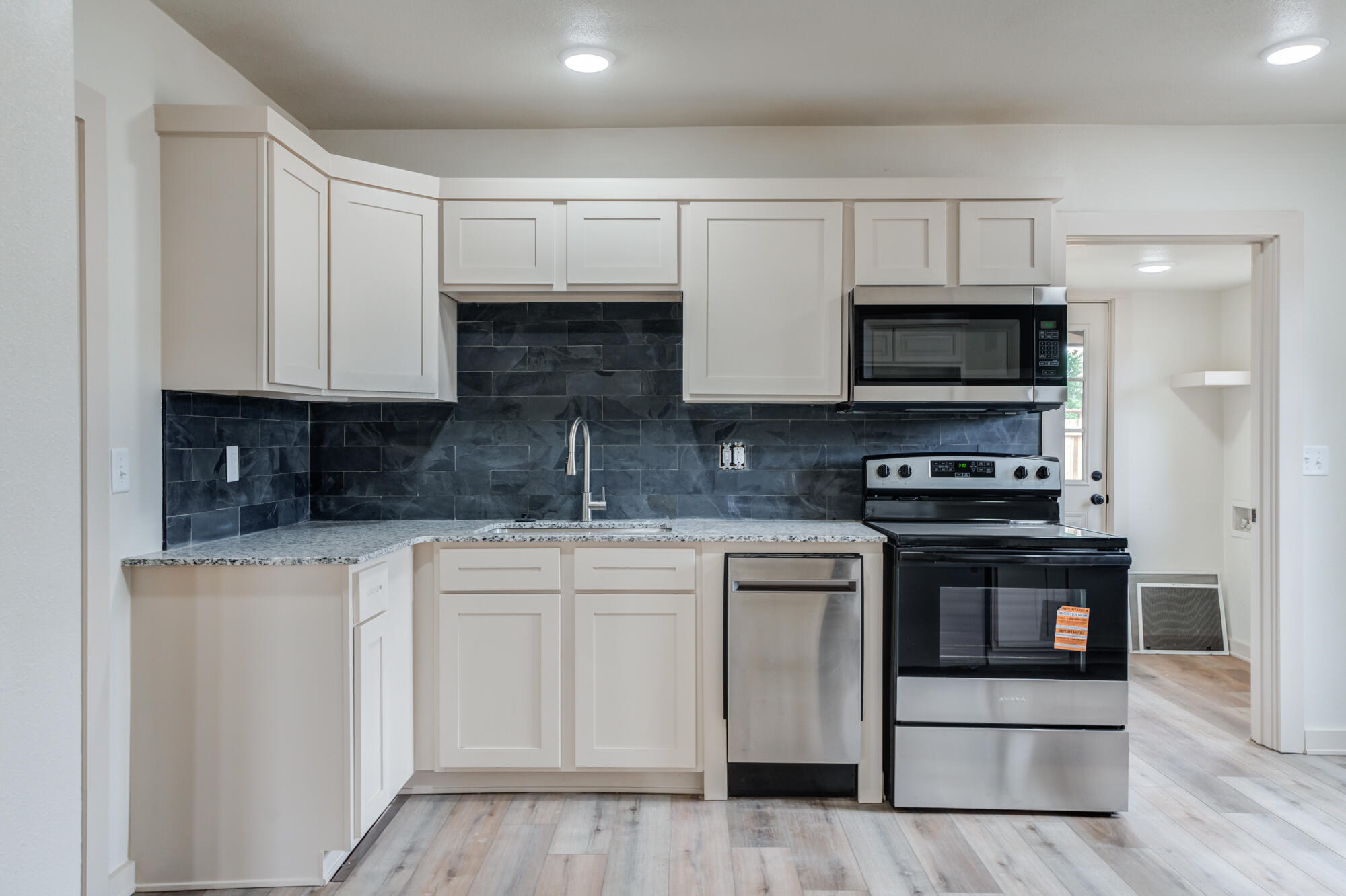 315 West Garza Street Slaton, TX 79364 - Photo 13 of 35 a kitchen with stainless steel appliances granite countertop a stove a sink and a microwave