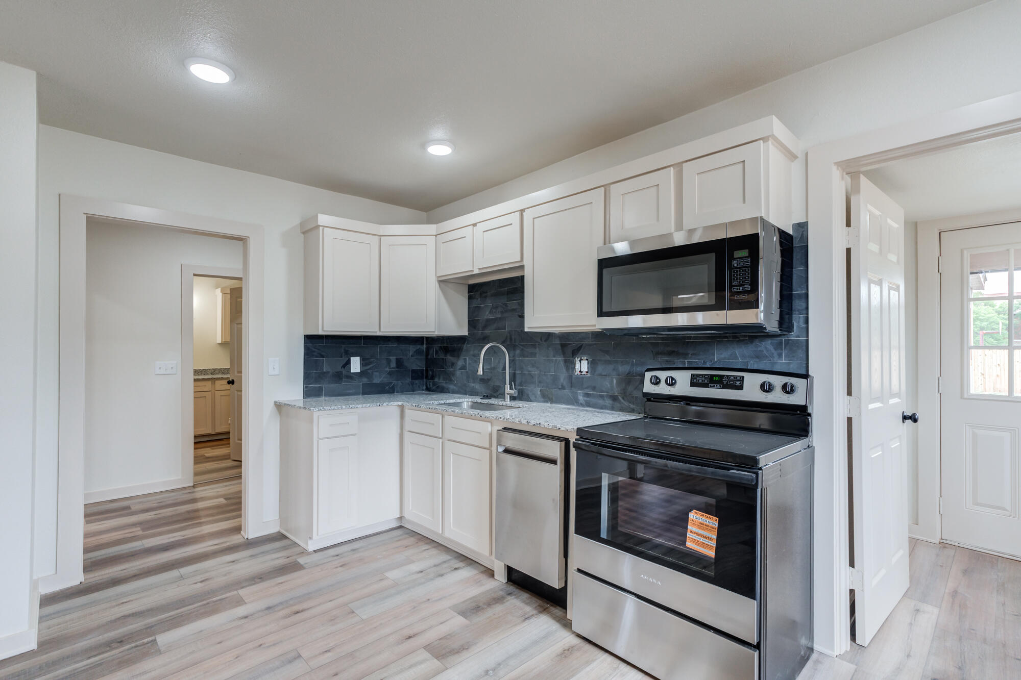 315 West Garza Street Slaton, TX 79364 - Photo 15 of 35 a kitchen with stainless steel appliances granite countertop a stove a microwave and cabinets