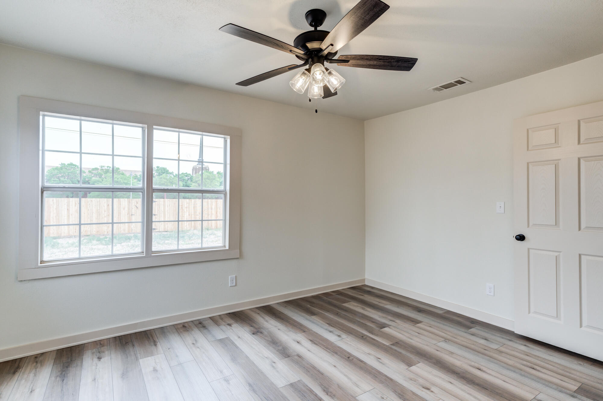 315 West Garza Street Slaton, TX 79364 - Photo 27 of 35 a view of an empty room with a window and wooden floor