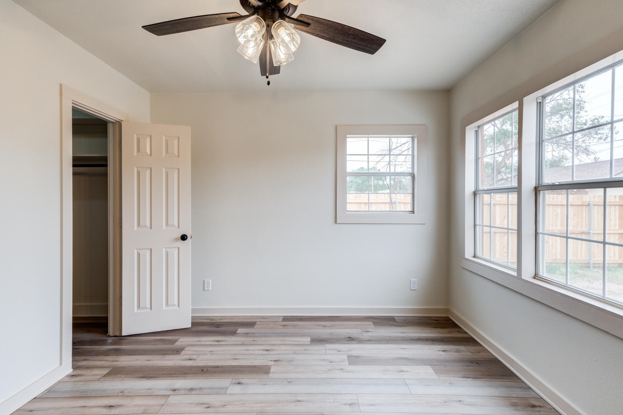 315 West Garza Street Slaton, TX 79364 - Photo 28 of 35 an empty room with wooden floor chandelier and windows