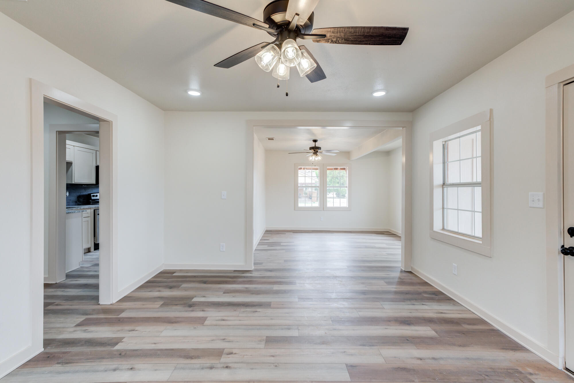315 West Garza Street Slaton, TX 79364 - Photo 9 of 35 wooden floor in an empty room with a window