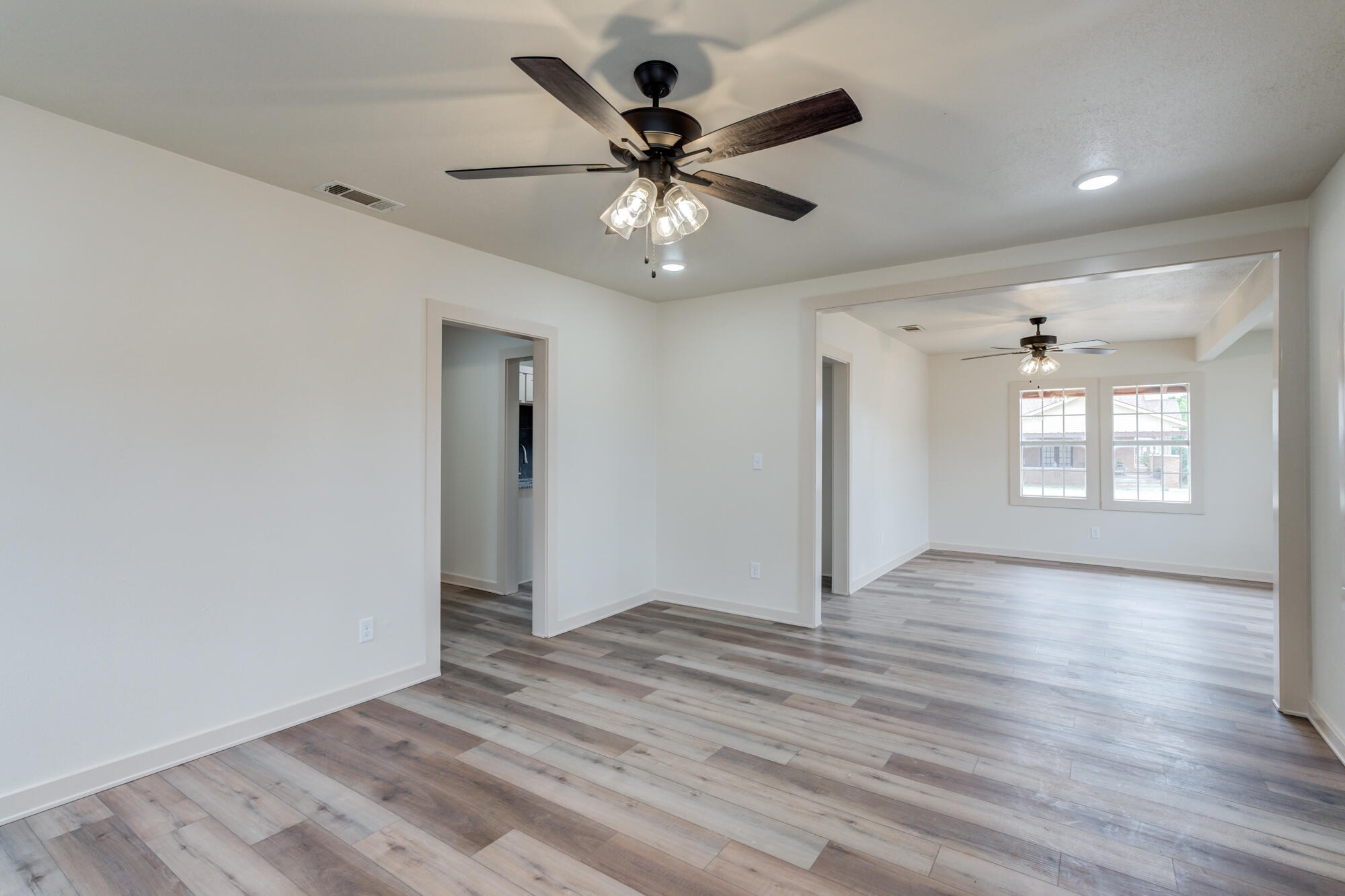 315 West Garza Street Slaton, TX 79364 - Photo 10 of 35 a view of an empty room with window and wooden floor