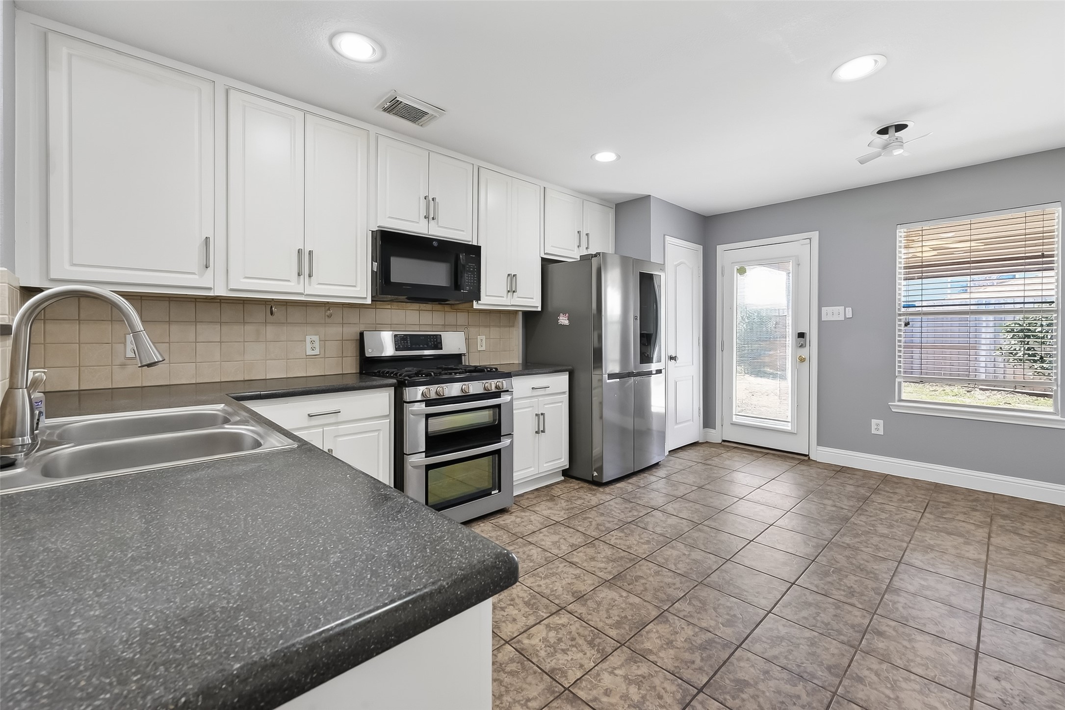 29603 Golden Vines Lane Spring, TX 77386 - Photo 9 of 23 a kitchen with stainless steel appliances granite countertop a stove a sink and a refrigerator