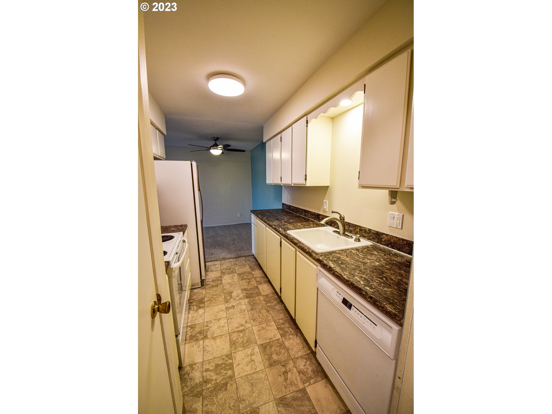 950 Evergreen Road, Unit 312 Woodburn, OR 97071 - Photo 4 of 16 a kitchen with stainless steel appliances granite countertop a sink and a refrigerator