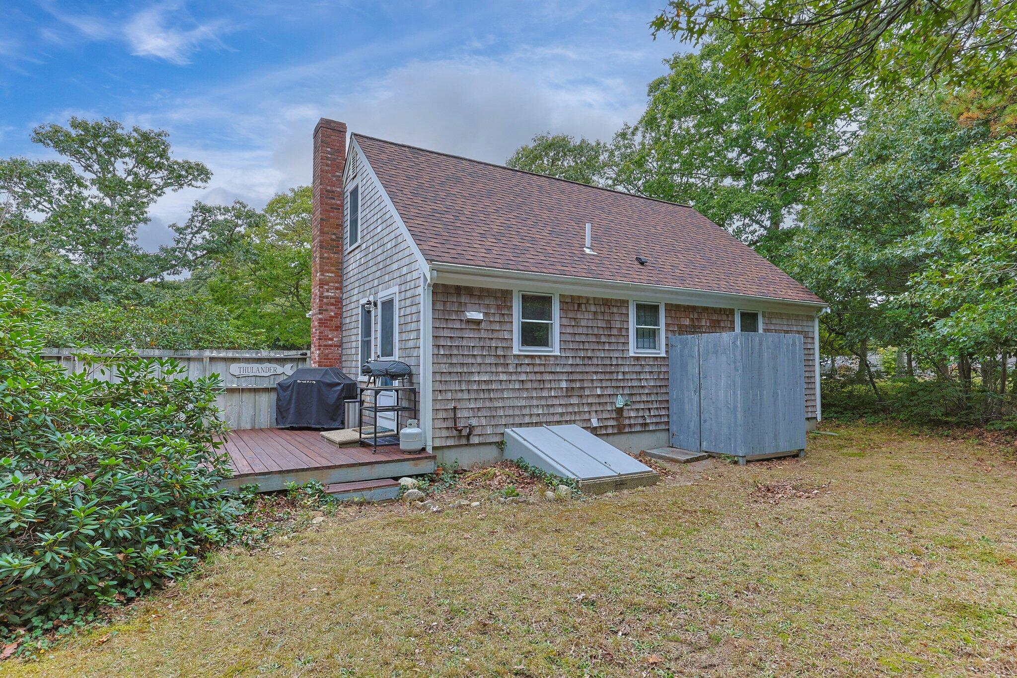 243 Commons Way Brewster, MA 02631 - Photo 26 of 32 a backyard of a house with table and chairs