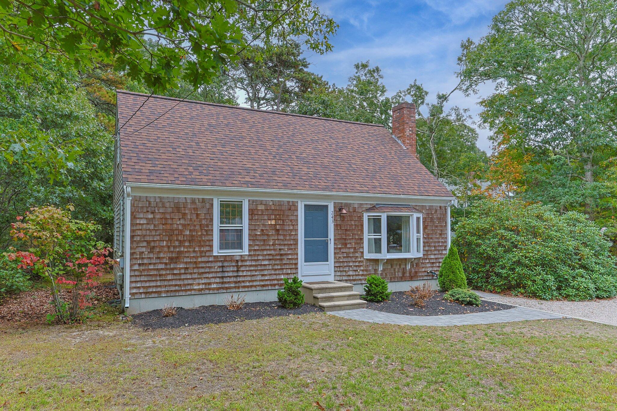 243 Commons Way Brewster, MA 02631 - Photo 32 of 32 a front view of a house with a yard and garage