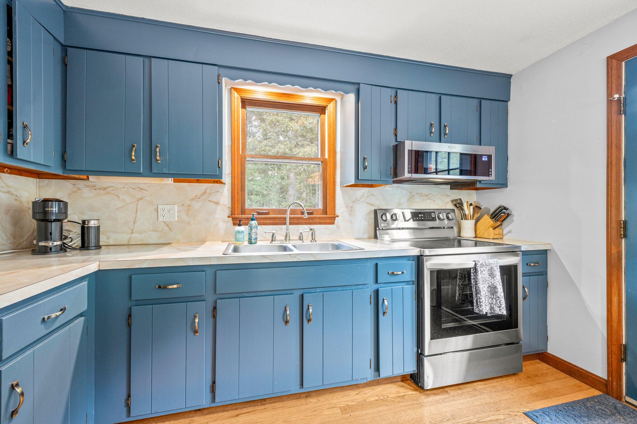 243 Commons Way Brewster, MA 02631 - Photo 8 of 32 a kitchen with stainless steel appliances granite countertop a stove a sink and a microwave