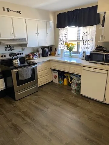 a kitchen with stainless steel appliances granite countertop a stove a sink and a microwave