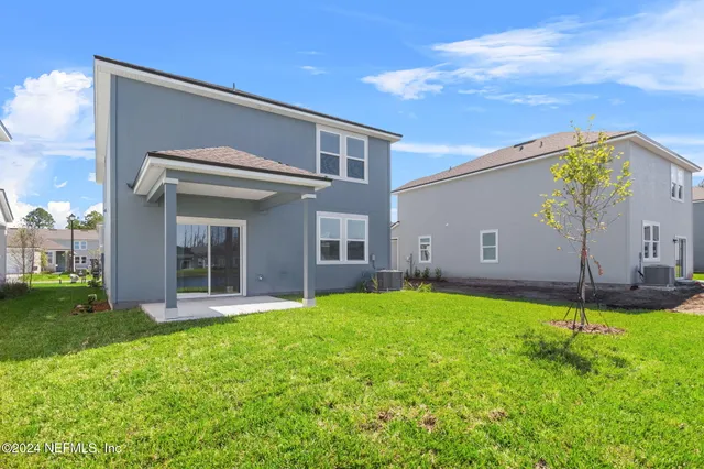 a house that has a big yard plants and a yard in the back