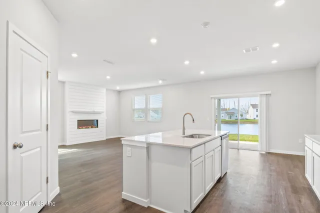 a kitchen with a sink cabinets and wooden floor