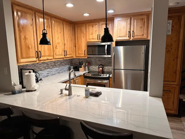 a kitchen with kitchen island a sink appliances and cabinets