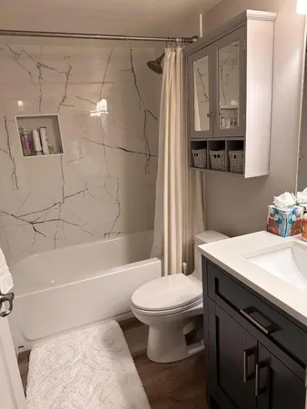 a bathroom with a sink a toilet and shower