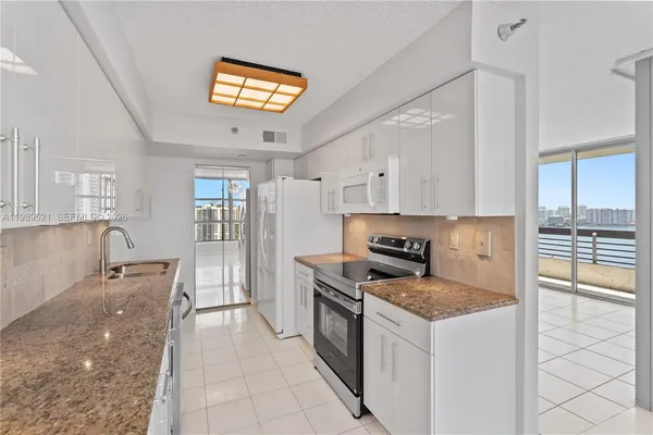 a kitchen with stainless steel appliances granite countertop a sink and a microwave