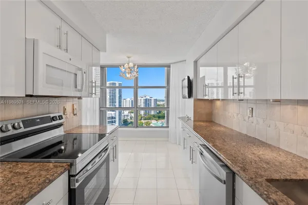 a kitchen with stainless steel appliances granite countertop a refrigerator and a stove top oven