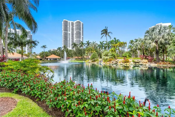 a view of a tall white building and a palm tree