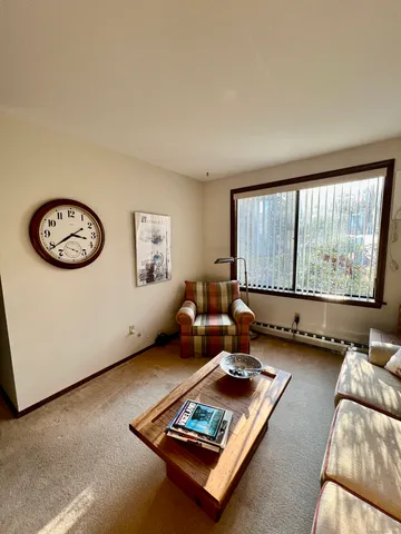 a living room with furniture a flat screen tv and a large window