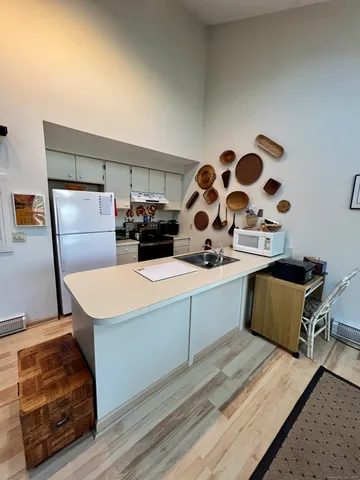 a living room with hard wood flooring and gym equipment