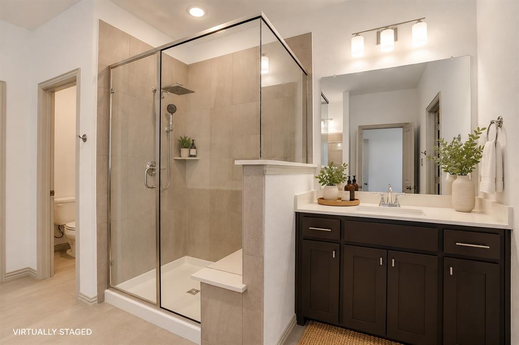 421 Matchbox Street Argyle, TX 76226 - Photo 19 of 40 Glass-enclosed shower with a rainfall showerhead and handheld sprayer, complemented by a built-in shelf