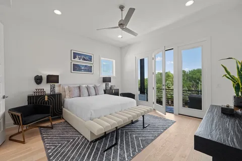 a spacious bedroom with a bed a couch and a large window