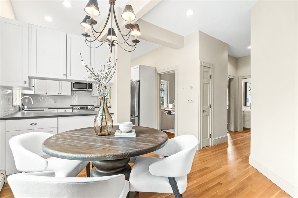 207 Weston Road Wellesley, MA 02482 - Photo 11 of 23 a kitchen with stainless steel appliances a dining table chairs and chandelier
