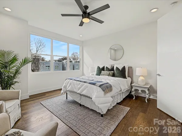 a bedroom with a large bed rug and wooden floor