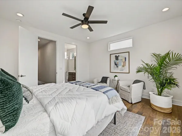 a spacious bedroom with a bed and a potted plant
