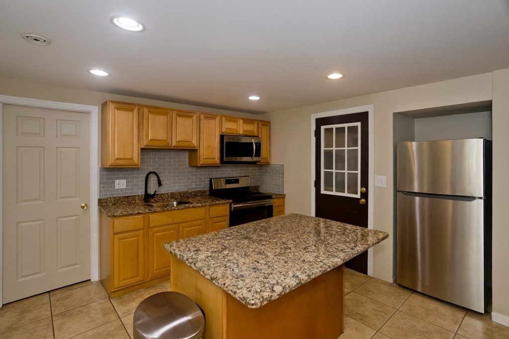 34 Temby Street Springfield, MA 01119 - Photo 2 of 22 a kitchen with a refrigerator a stove a sink a counter space and cabinets