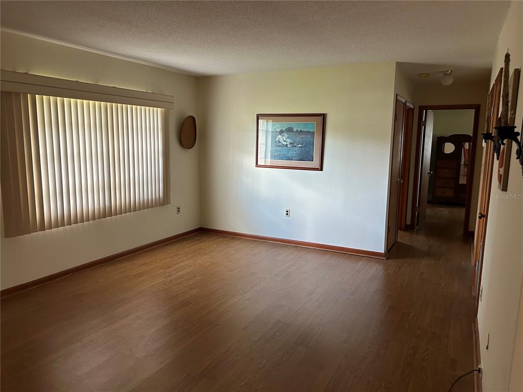 24121 Armadillo Road Astor, FL 32102 - Photo 11 of 11 an empty room with wooden floor and windows