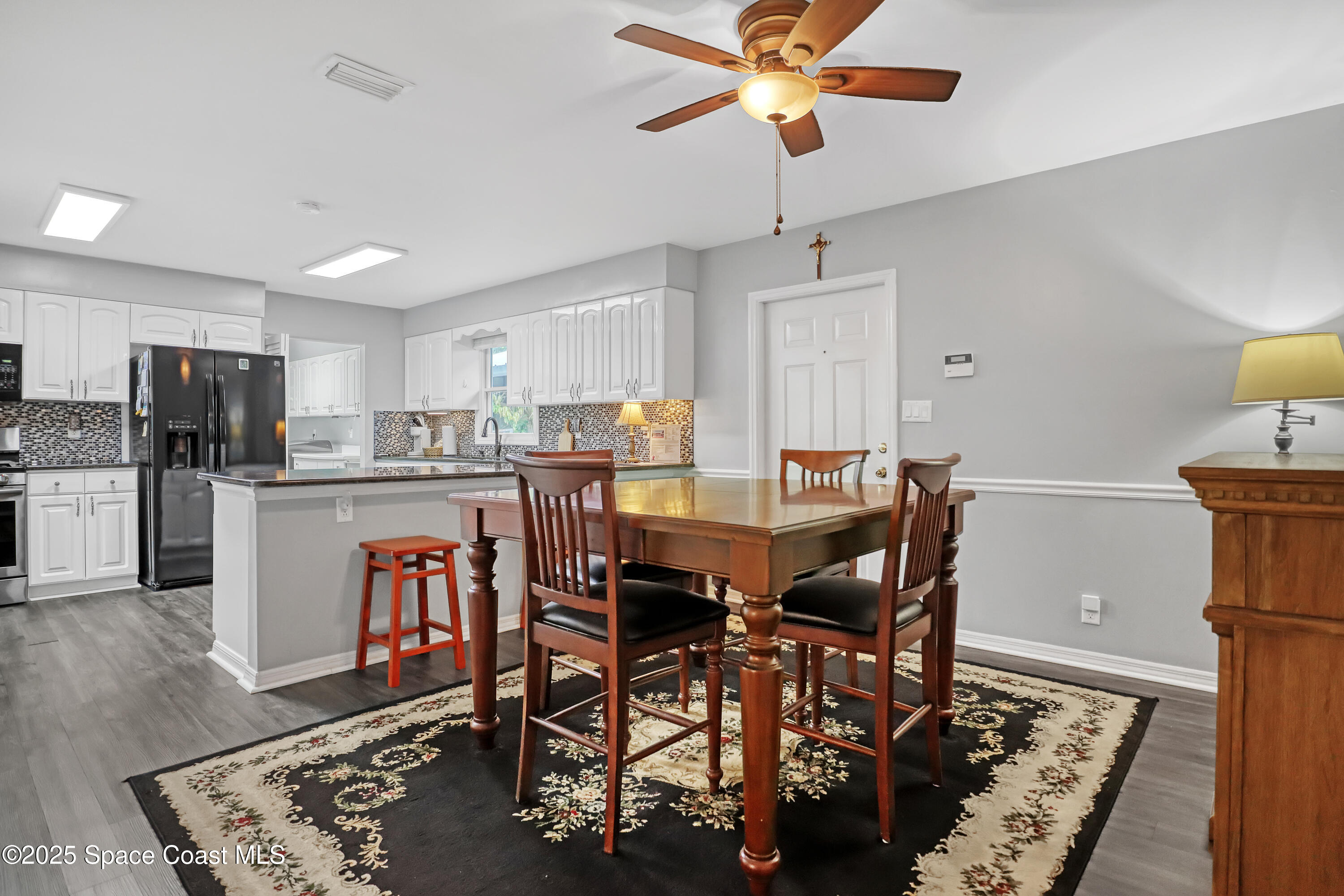 5280 Curtis Boulevard Cocoa, FL 32927 - Photo 16 of 45 a kitchen with stainless steel appliances kitchen island granite countertop a table chairs and a refrigerator