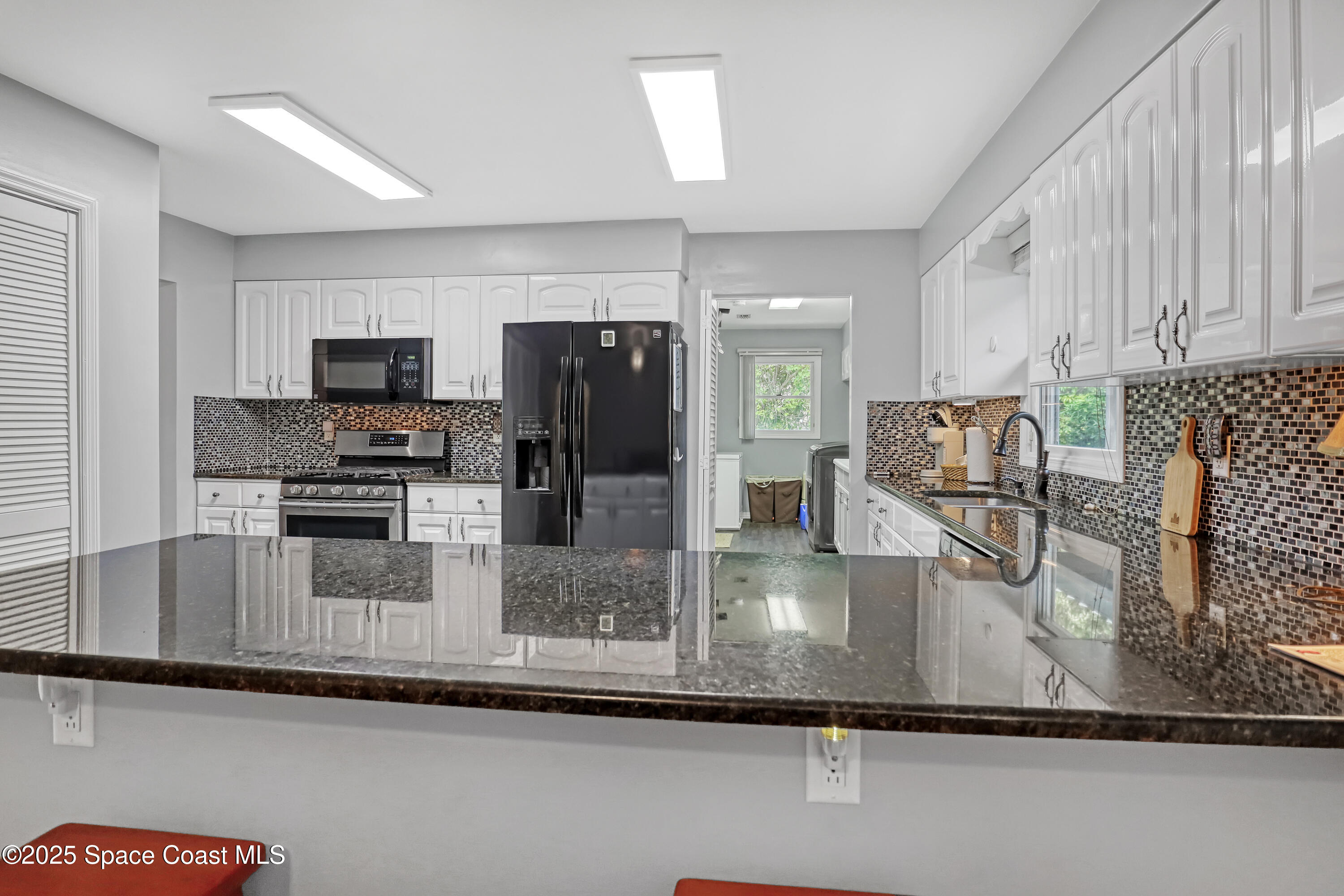 5280 Curtis Boulevard Cocoa, FL 32927 - Photo 19 of 45 a kitchen with a refrigerator a microwave a sink and cabinets