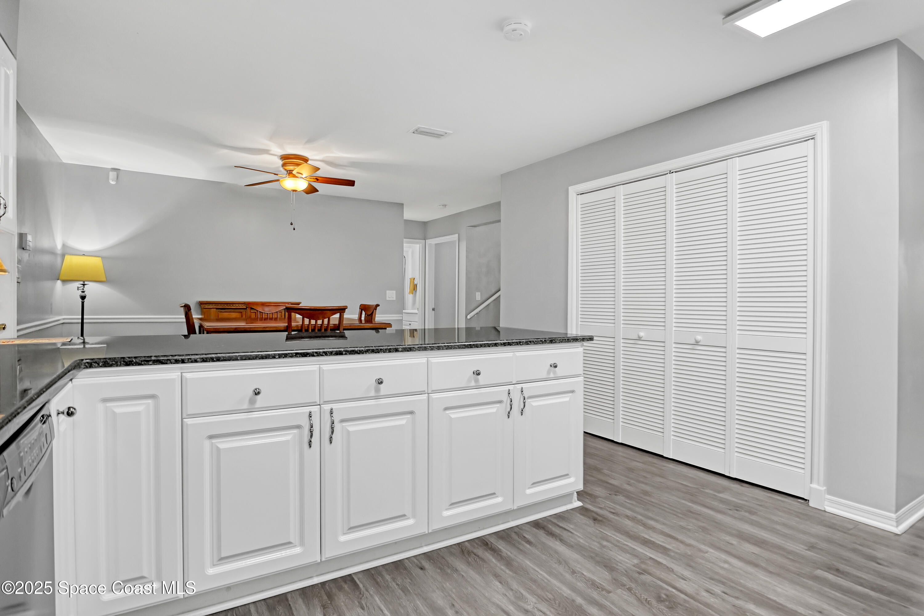 5280 Curtis Boulevard Cocoa, FL 32927 - Photo 23 of 45 a kitchen with granite countertop white cabinets and a wooden floor