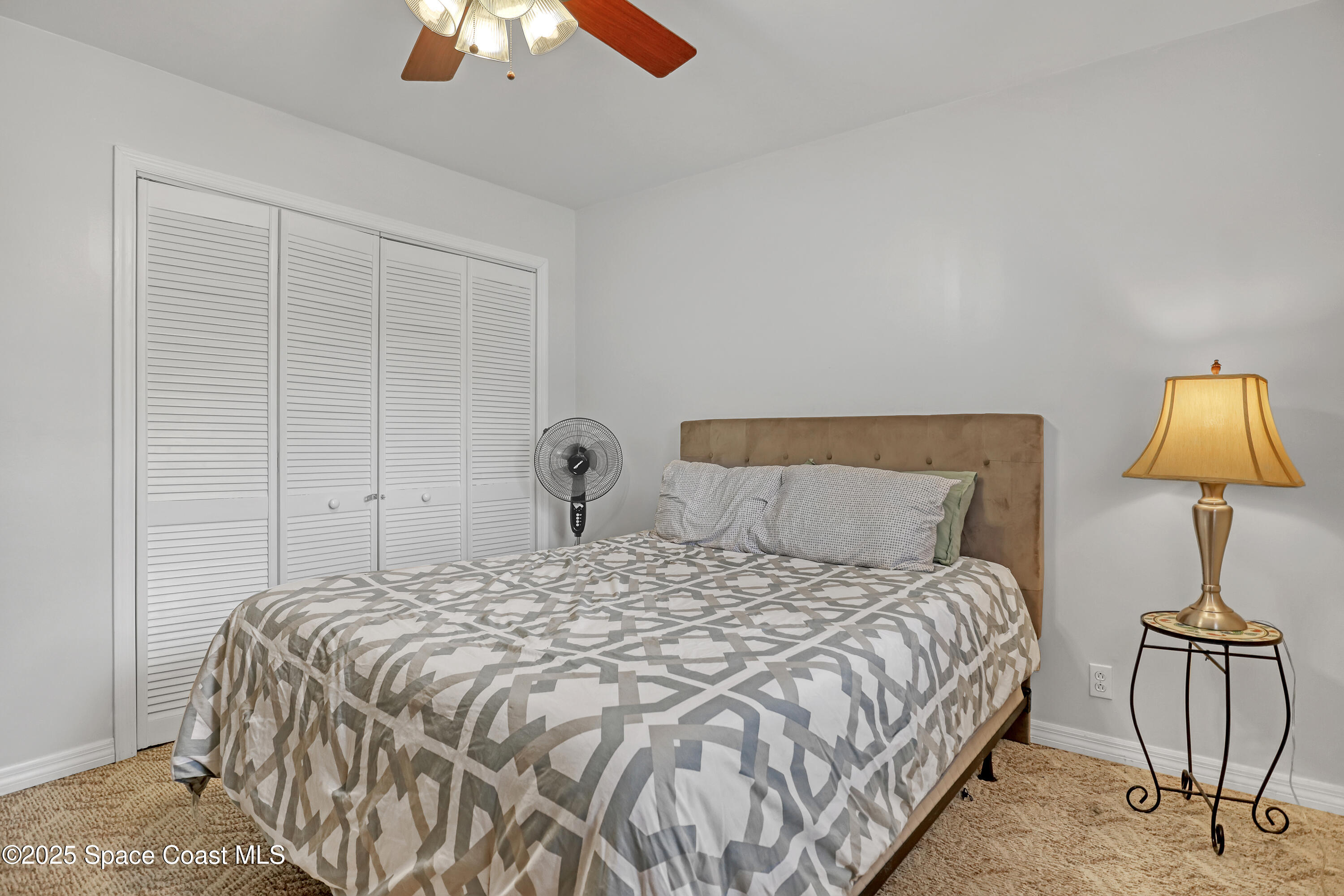 5280 Curtis Boulevard Cocoa, FL 32927 - Photo 33 of 45 a bedroom with a bed and a lamp